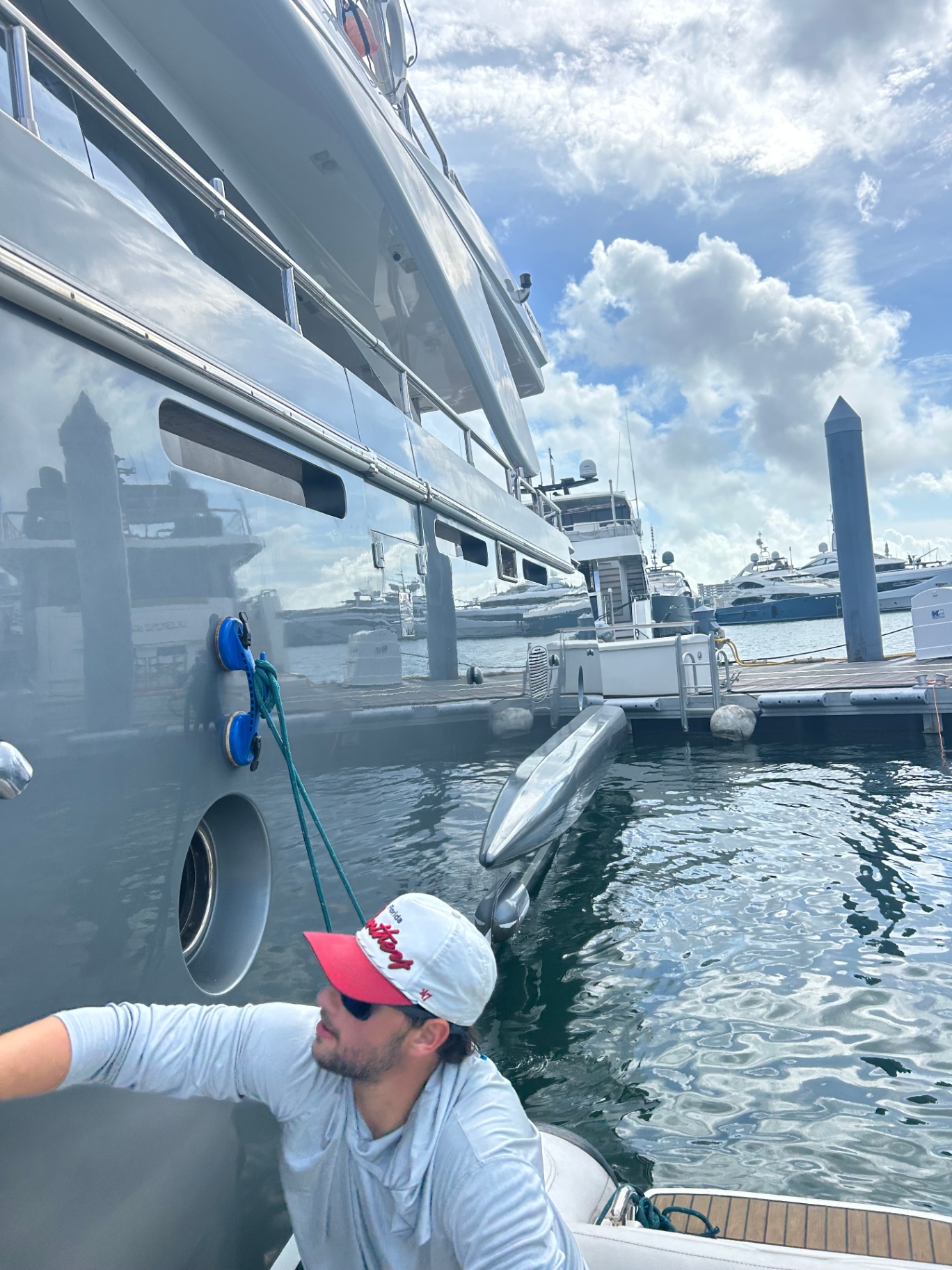 Tender alongside a superyacht being detailed in a Miami marina