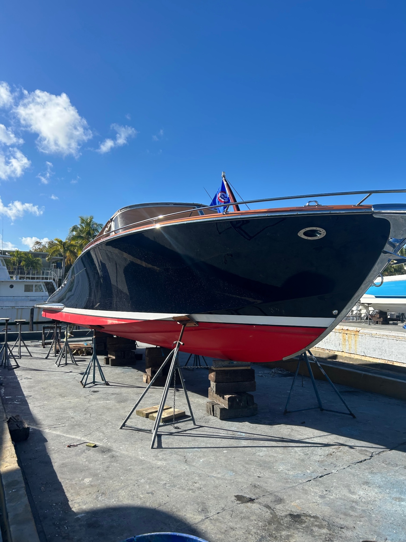 Black hull sport yacht with red bottom paint on stands at the yard